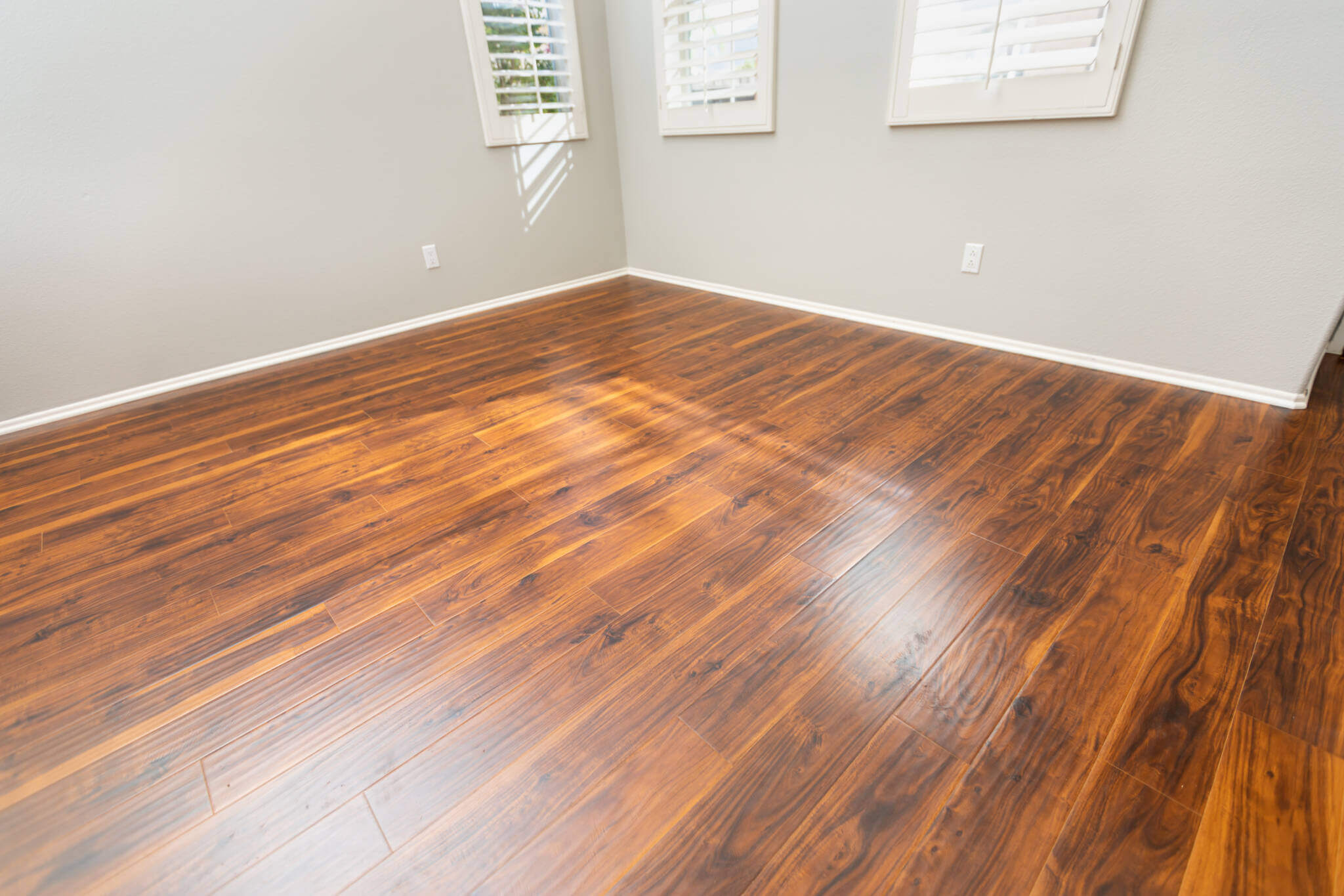 Newly Installed Brown Laminate Flooring And Baseboards In Home.